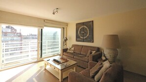 Een woonkamer met een bank, een salontafel, een lamp en een schaakbord.