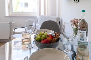 A dining table with a bowl of fruit, wine glasses, and a bottle of alcohol. - Apartment in Koblenz near Deutsches Eck (Koblenz)