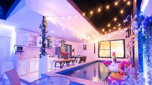 Une maison moderne dotée d’une piscine, d’un coin repas et d’une cuisine.