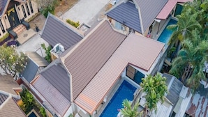 Un quartier résidentiel comprenant plusieurs maisons, une piscine et un petit jardin.