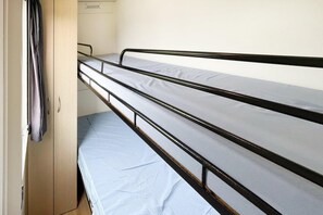 A bunk bed with metal railings and a single bed below.