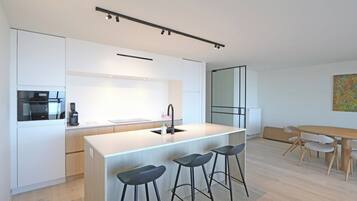 Een moderne keuken met een centraal eiland, barkrukken, een eettafel met stoelen en een koffieapparaat.