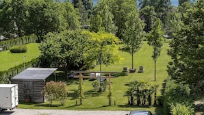 A well-maintained garden with a wooden structure, a lawn, and a view of a lake. - Apartment in Mezzolago by Lake Ledro (Mezzolago (TN))