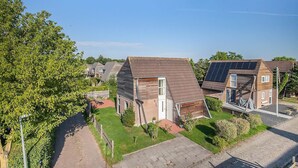 A residential area with houses featuring sloped roofs and solar panels. - Holiday Home in Grou with Whirlpool & Terrace (Grou)