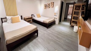A hotel room with two beds, a wooden dresser, a television, and a wardrobe. - La Palme (El Nido)