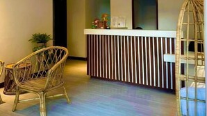 A reception area with a counter, wicker chairs, and a hanging chair. - La Palme (El Nido)