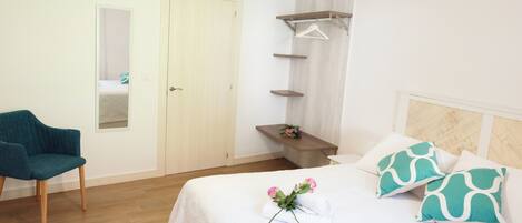 Une chambre à coucher avec un lit, une chaise, une armoire et un miroir.
