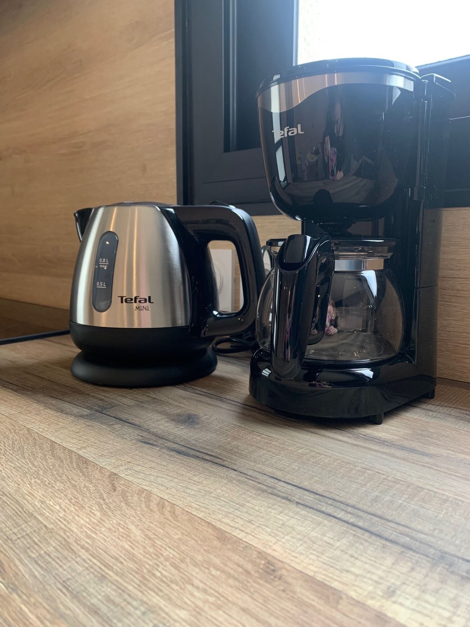 A Tefal Mini coffee maker and kettle on a wooden countertop.