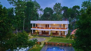 A modern two-story house with a swimming pool, surrounded by lush greenery. - Voye Homes Signature Pool Resort Varkala (Varkala)