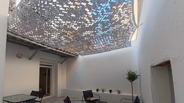 A courtyard with a table and chairs, a small plant, and a decorative ceiling. - Bright cocoon with private courtyard (Salses-le-Château)