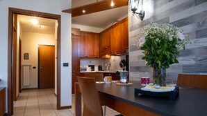 Una cocina moderna con armarios de madera, una mesa de comedor con sillas y un jarrón de flores sobre la mesa.