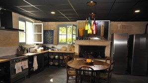 A kitchen with a central island, a stove, a refrigerator, and a dining table with chairs. - Your Château in the vineyards near Bordeaux (Arveyres)