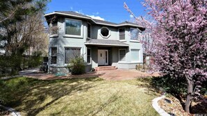 A two-story house with a front porch, a garage, and a well-maintained lawn.