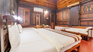 Una habitación de madera con dos camas, un espejo y una pequeña mesa con una planta.