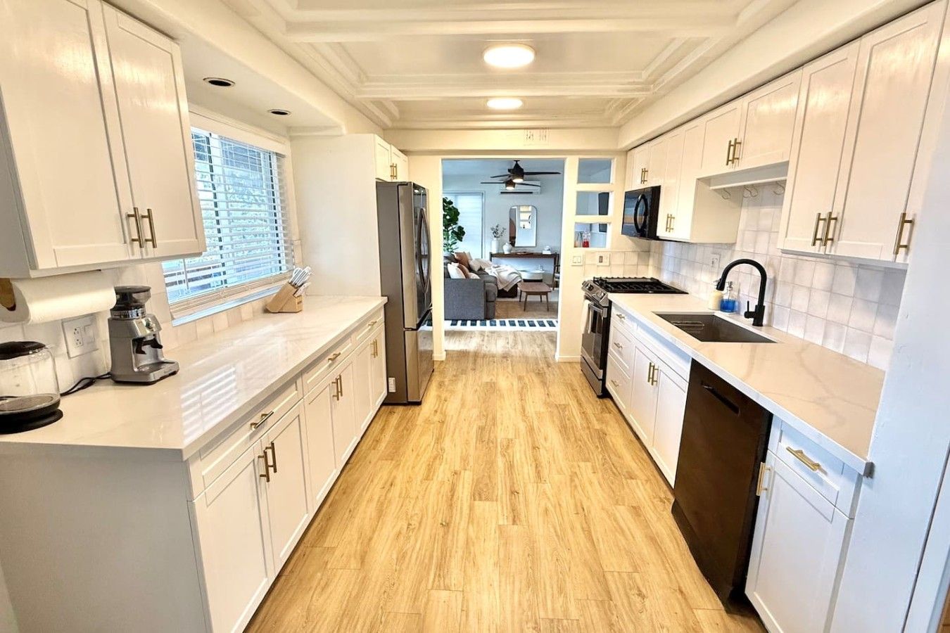 A modern kitchen with white cabinetry, a refrigerator, a stove, and a dishwasher.