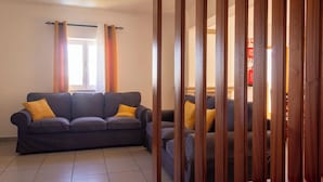 Un salon avec un canapé et une cloison en bois.