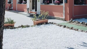 A building with a red facade, white awning, and potted plants. - Hotel Edelweiss Mantova (Castel d'Ario)
