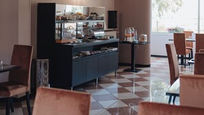 A cafe with checkered flooring, a counter with food display, and seating arrangements. - Hotel Edelweiss Mantova (Castel d'Ario)