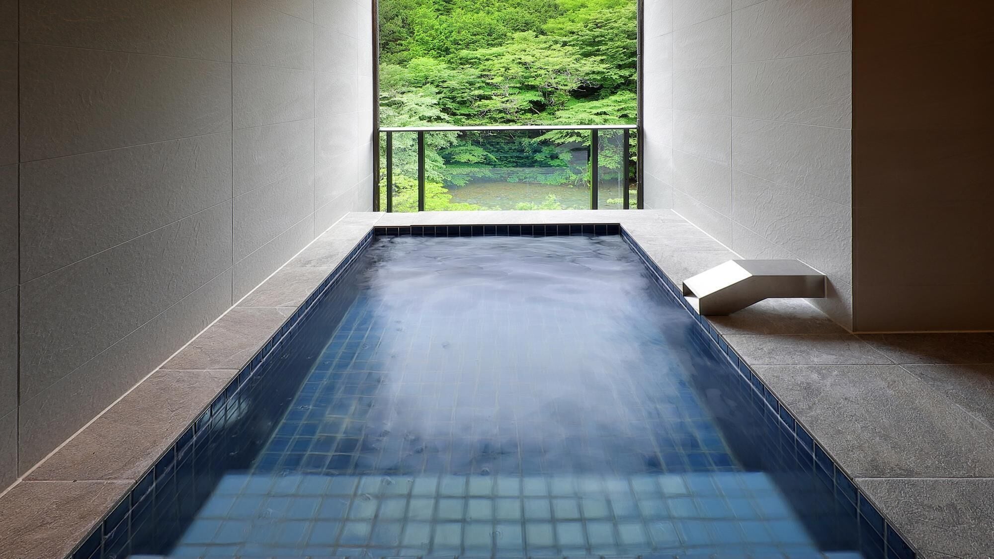 Banheira de hidromassagem moderna em ambiente interno, com vista para uma floresta verde exuberante através de uma janela de vidro.
