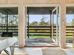A modern room with a large sliding glass door leading to an outdoor deck.