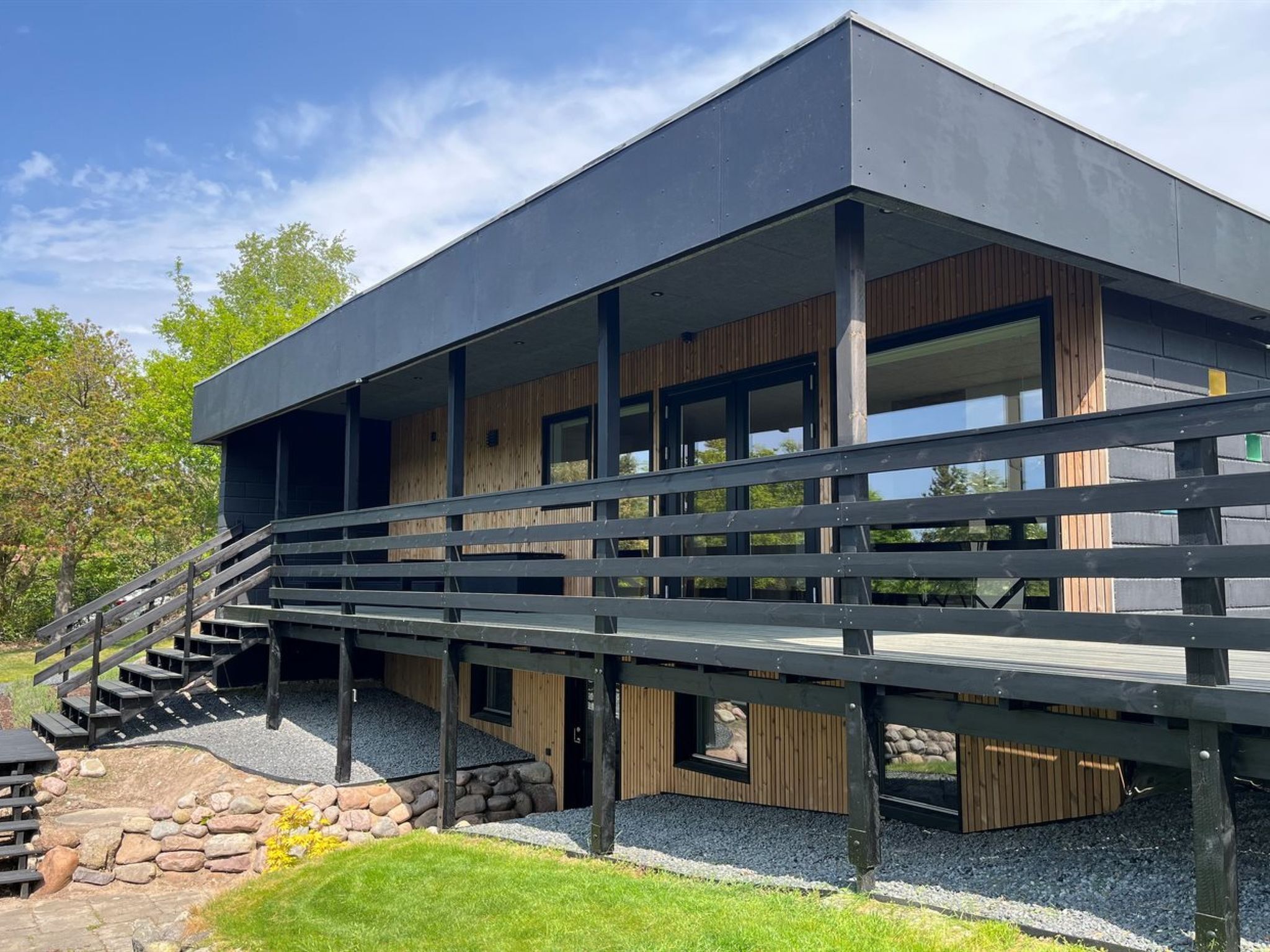 A modern building with a staircase leading to a wooden deck.