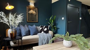 Un salon confortable avec un canapé, une table basse et une plante en pot.