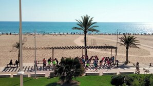 A beach with a covered area and palm trees.