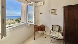 Une pièce dotée d’une grande fenêtre donnant sur la mer et offrant une vue sur le paysage côtier.