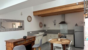 A modern kitchen with a wooden countertop, a dining table with woven placemats, and a built-in oven.