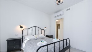 Ein Schlafzimmer mit einem Bett, Nachttischen und einer Klimaanlage.