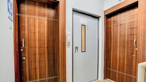 Un corridoio con due porte in legno, una delle quali è una porta di sicurezza.