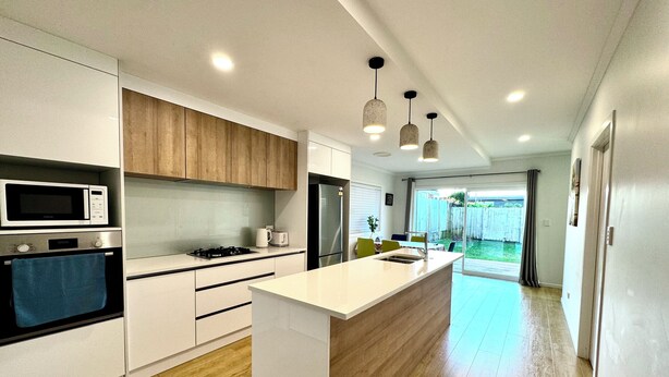 A modern kitchen with a central island, built-in appliances, and pendant lighting. - Newly Built 3 BDMs Besides Chartwell Shopping Mall (Hamilton)