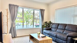 A modern living room with a leather sofa, a wooden coffee table, and a TV stand. - Newly Built 3 BDMs Besides Chartwell Shopping Mall (Hamilton)