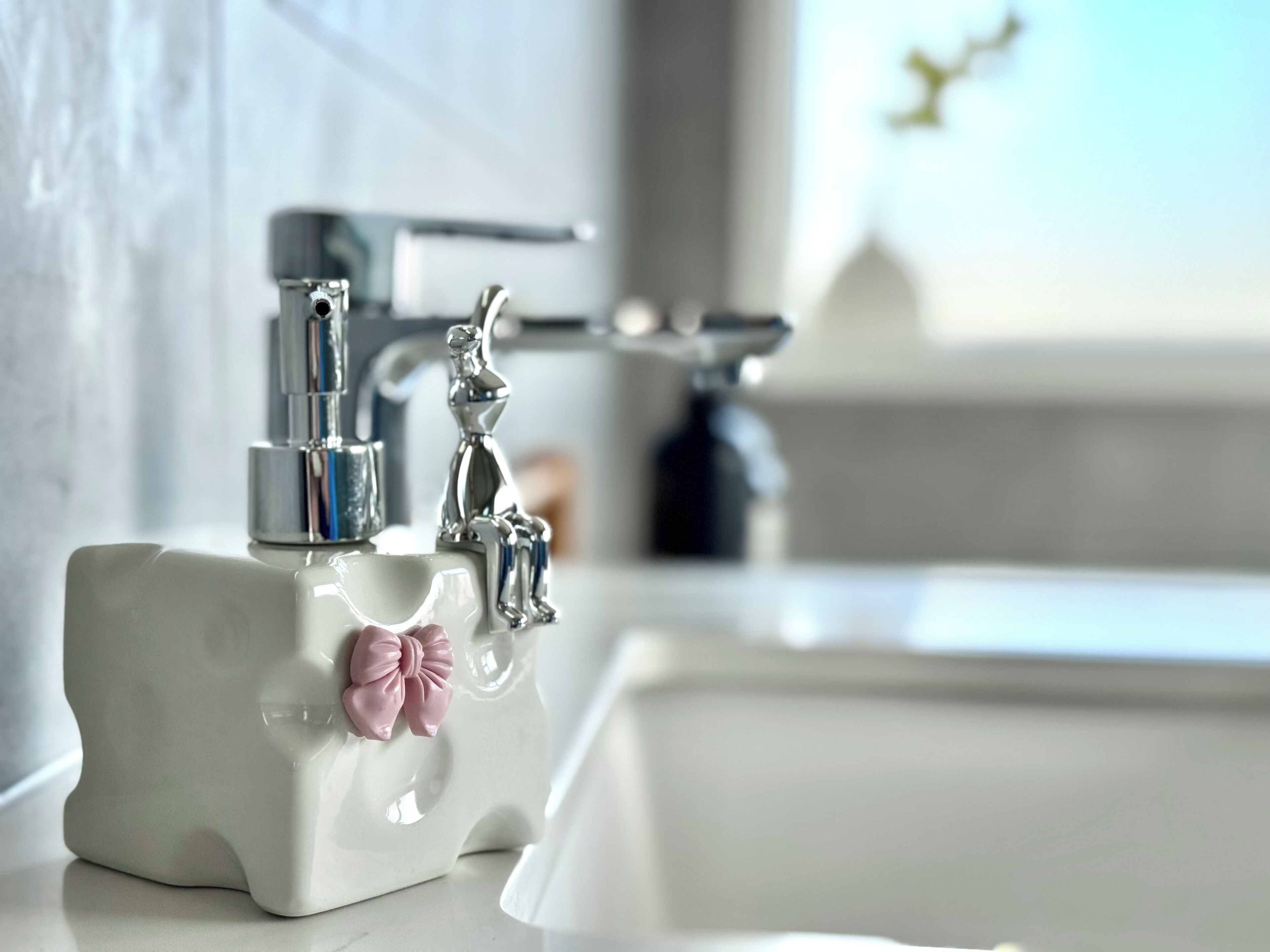 Un lavandino da bagno con un moderno rubinetto e un porta sapone decorativo.