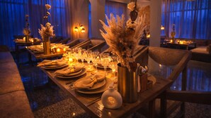 A dining area with tables set for a meal, candles, and decorative flowers. - The Vintage Villas Resort Ladakh - Luxury Stay with Mountain Views (Leh)