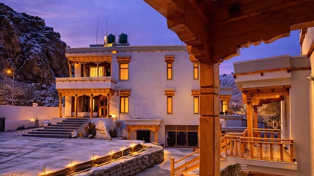 A hotel with a stone facade, wooden balconies, and outdoor lighting. - The Vintage Villas Resort Ladakh - Luxury Stay with Mountain Views (Leh)