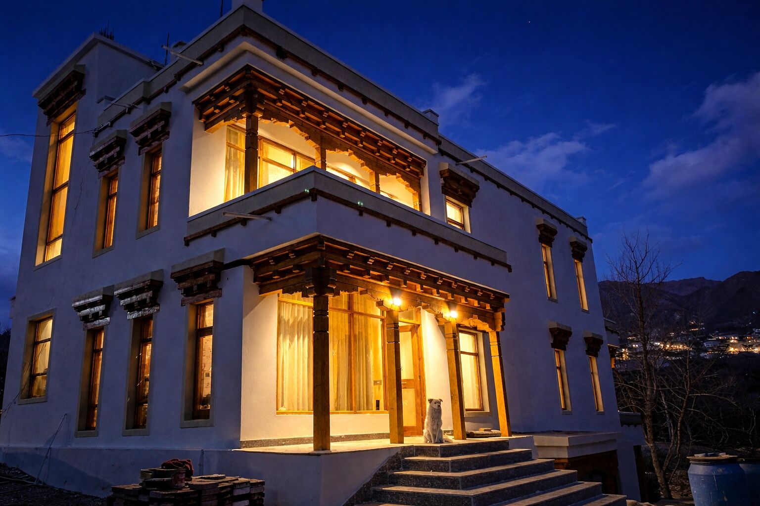 A two-story building with a porch, large windows, and a dog on the steps.