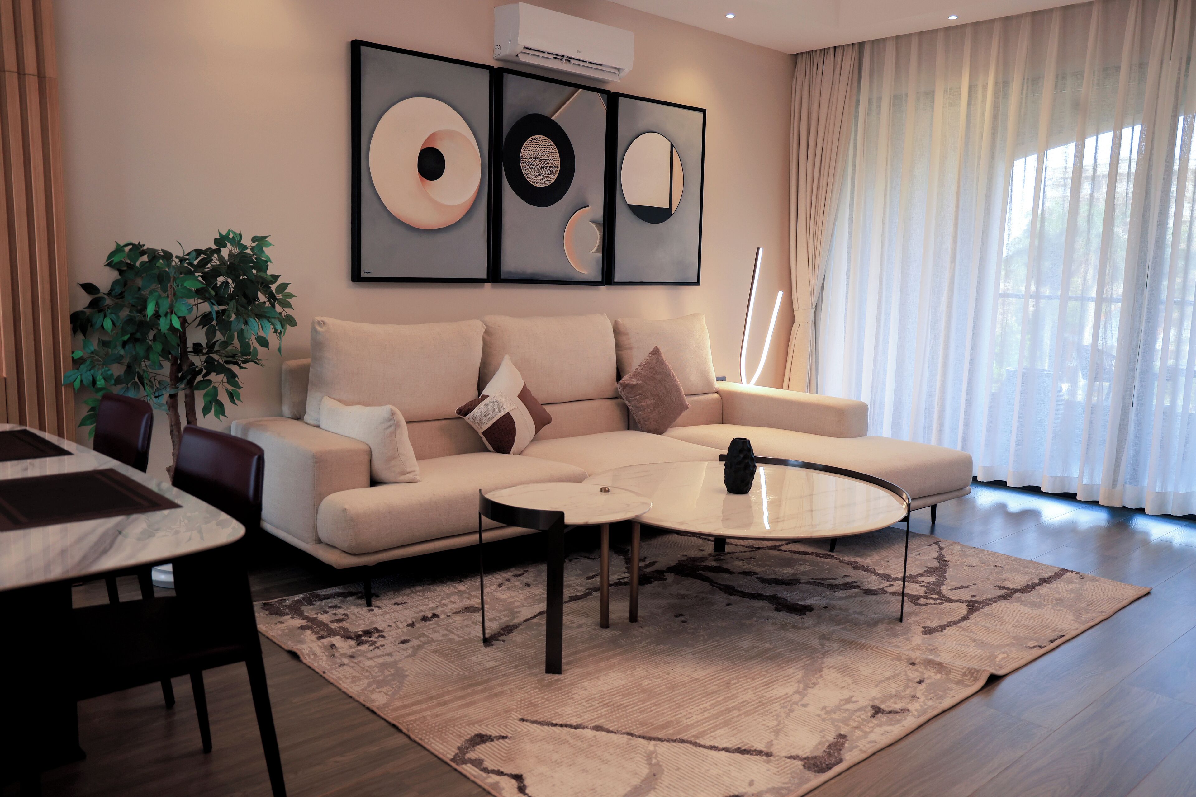 Een moderne woonkamer met een bank, salontafel en een eethoek.