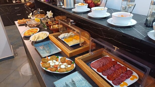 A buffet with various food items including meats, cheeses, and pastries. - Hotel Excelsior (Timisoara)