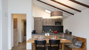 A modern kitchen with wooden cabinets, a built-in oven, and a black countertop. - Lovely apartment for 4 people with WIFI, pool, TV, balcony, pets allowed and panoramic view (Falera)