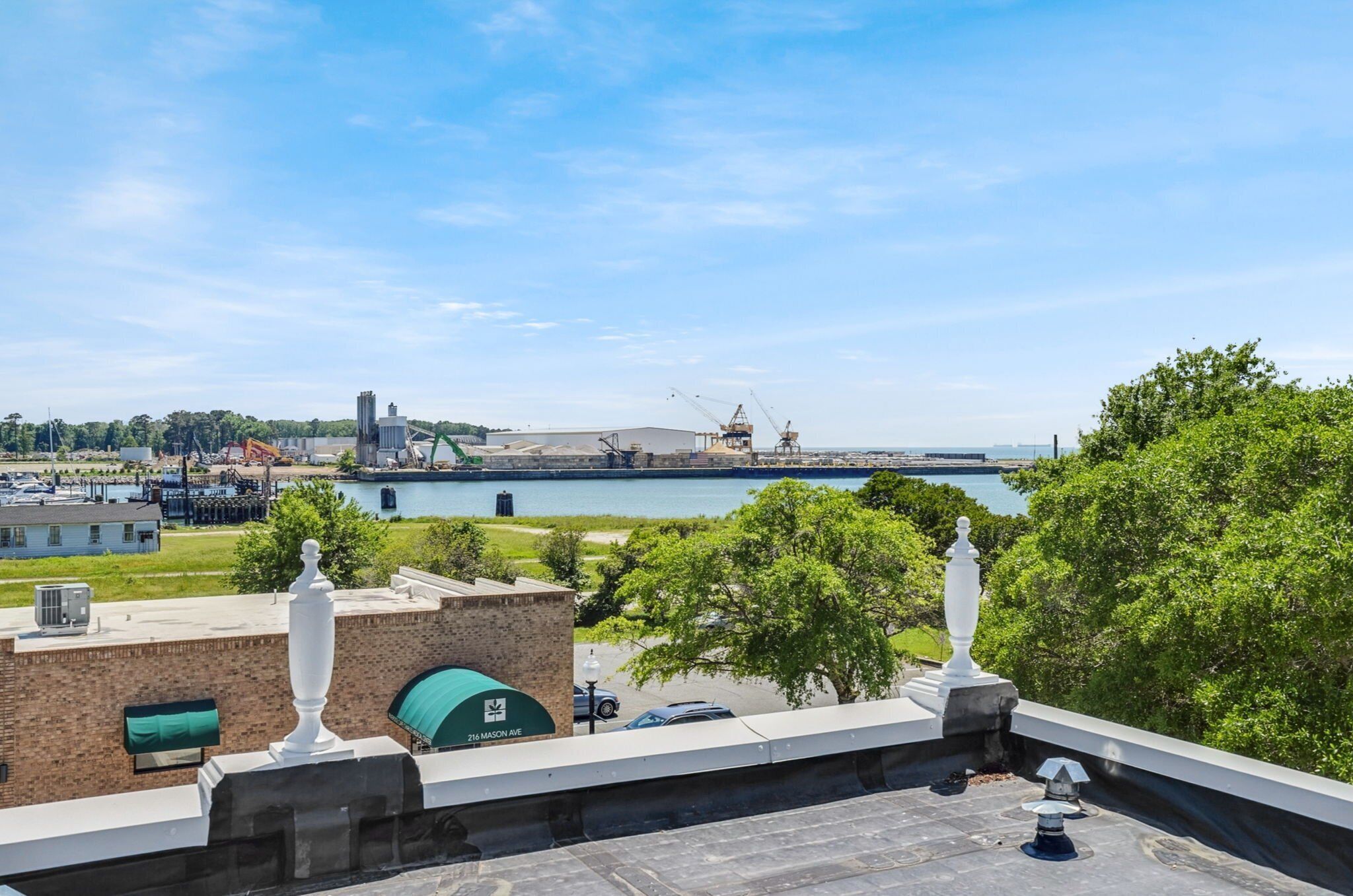 A rooftop terrace with a view of a port and a body of water.