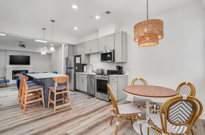 Relax in a spacious living area with a large dining table and comfortable seating, featuring a cozy seating area with a fireplace.
