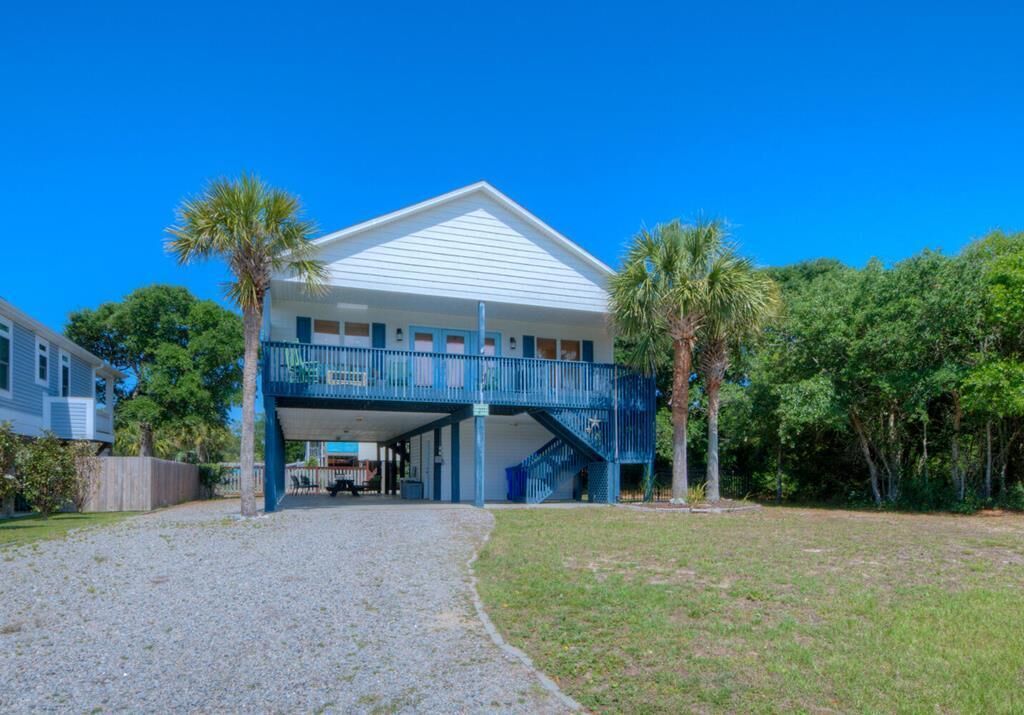A two-story house with a covered porch and a staircase leading to the upper level.