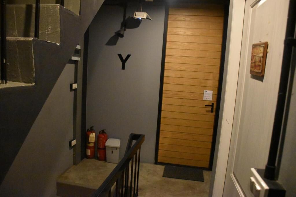 Un escalier étroit menant à une porte marquée d’un « Y ».