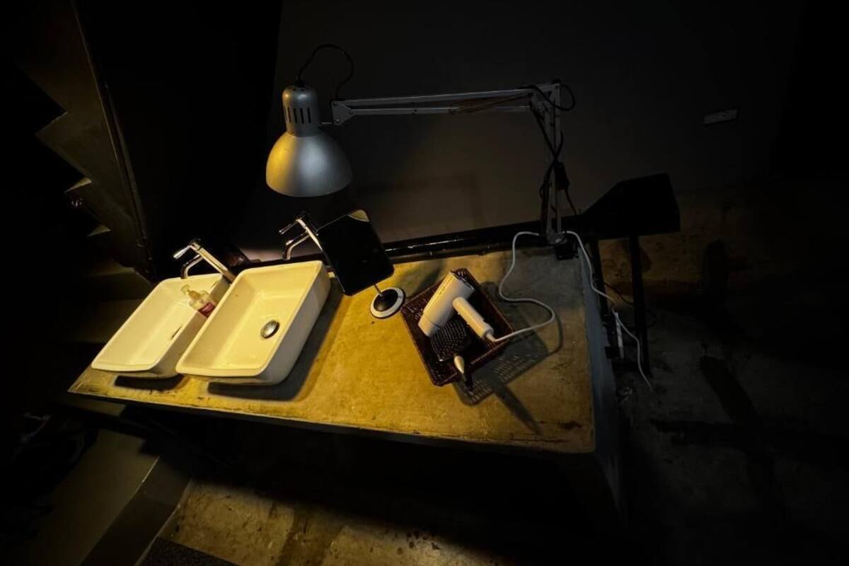 A workbench with two sinks, a lamp, and various tools.