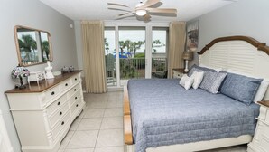 Un dormitorio con cama, cómoda y ventilador de techo.