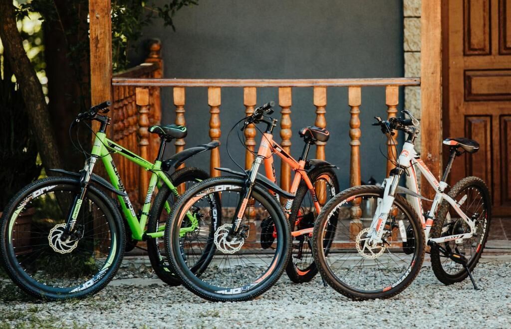 Quattro biciclette parcheggiate davanti a un cancello di legno.