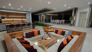 A modern living area with a kitchen, dining space, and seating arrangement. - Villa Origen Exclusive (Adeje)