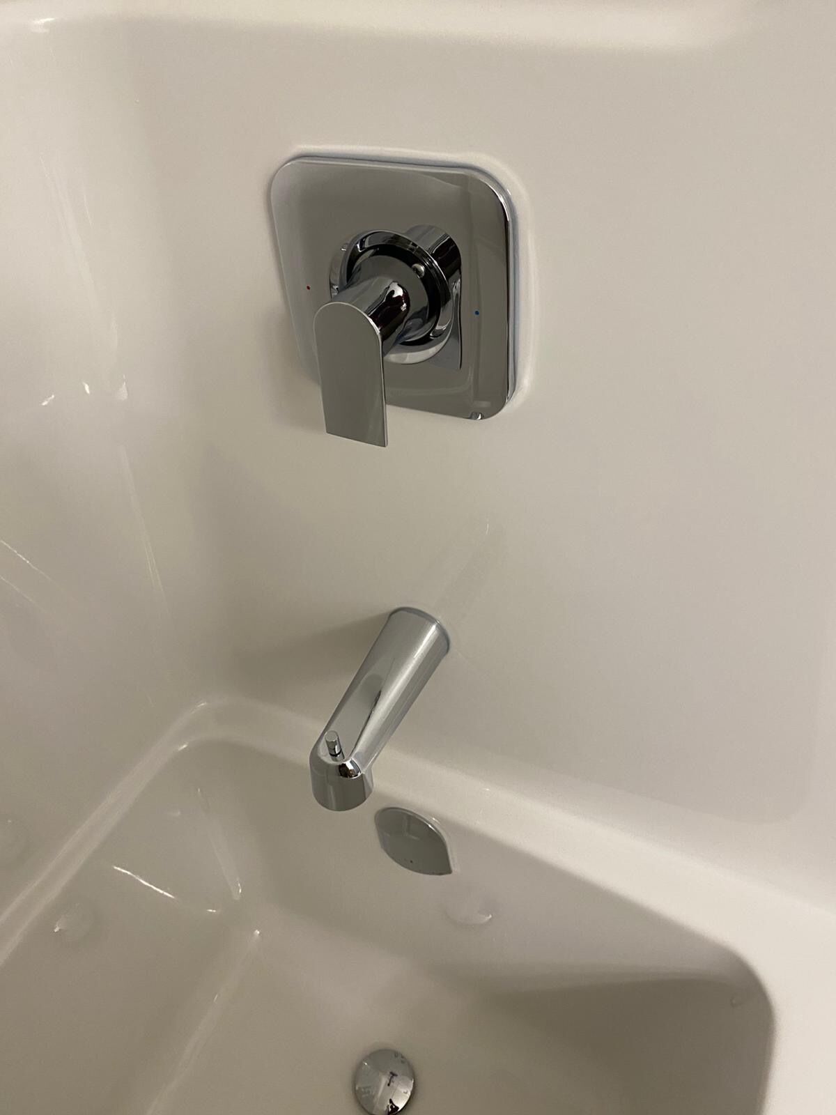 A white bathtub with a chrome faucet and a separate lever faucet.