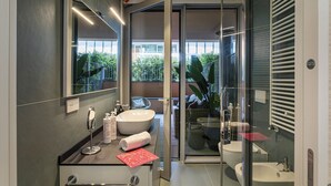 A modern bathroom with a large mirror, two sinks, and a glass shower enclosure. - Waterfront Dream by Wonderful Italy (Genova)